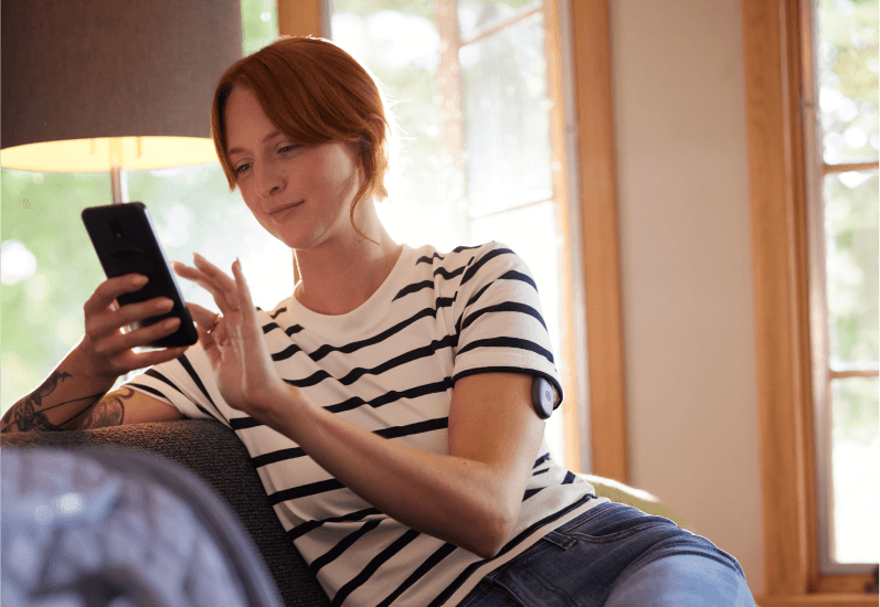 En Eversense-användare använder smartphone och mobilapp för att parkoppla sändare och länka en sensor med hjälp av en smartphone