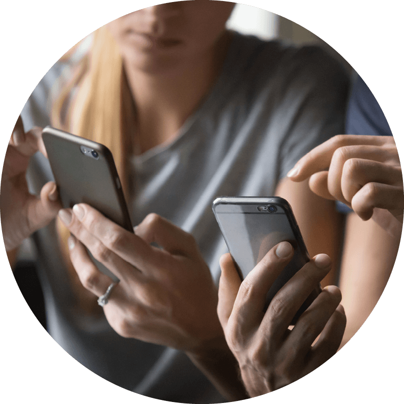 Två Eversense-användare som håller smartphones, en pekar på skärmen som förklarar data från CGM-enheten